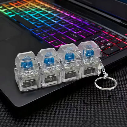 4 klavišų „clicker“ tipo antistresinis žaislas, klaviatūros imitacija, raktų pakabukas